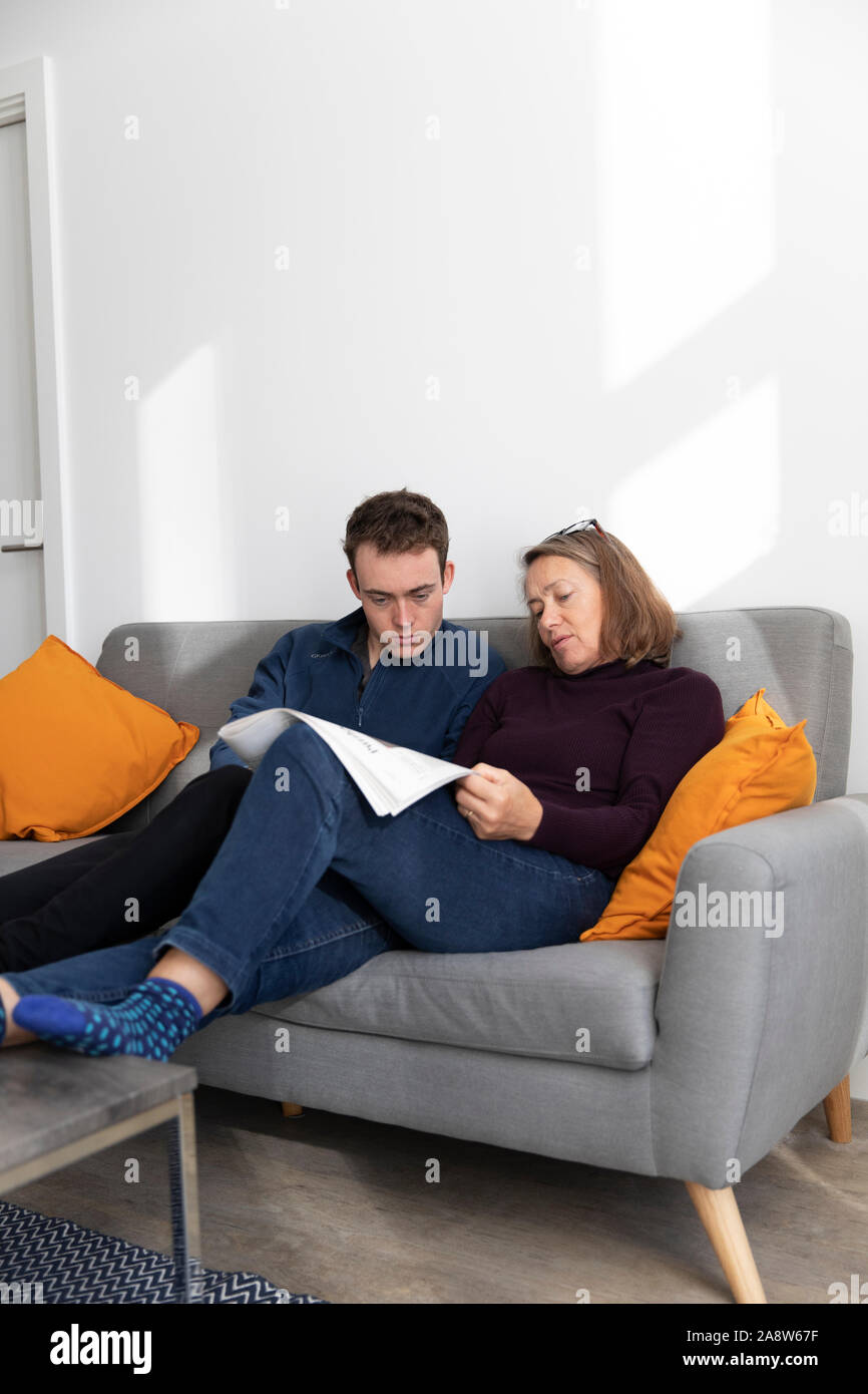 Mother and son attempting crossword in modern apartment Stock Photo Alamy