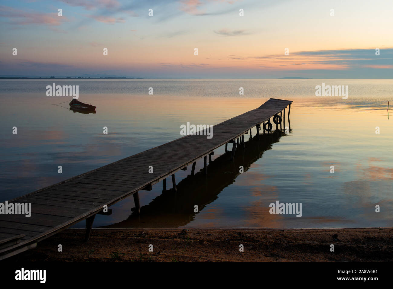 beautiful sunrise over water and silhouette of fishing boat Stock Photo ...
