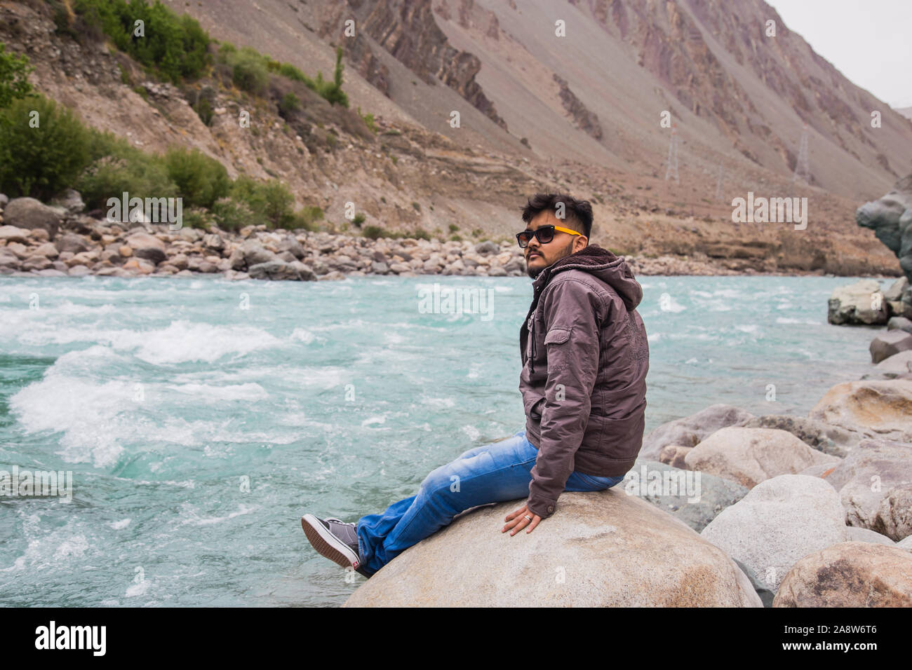 young Man sitting and Looking over a Valley with the Indus and Zanskar ...