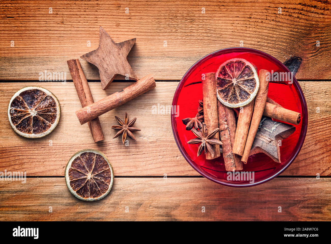 Top view of Christmas spices with dried orange and cinnamon on wooden table background, vintage christmas kitchen decor Stock Photo