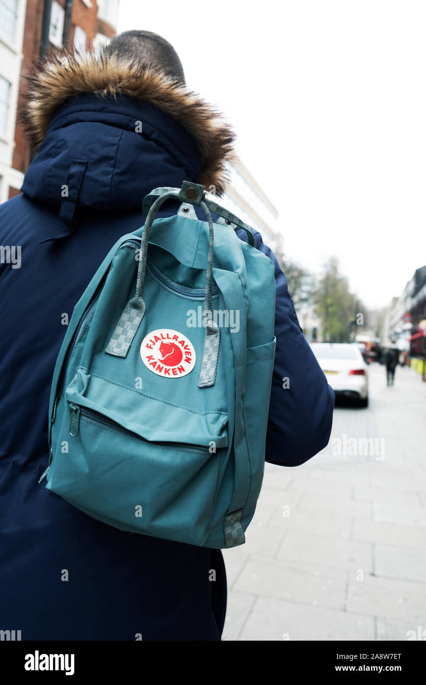 LONDON, UK - DECEMBER 30, 2018: A young man carrying a popular Fjallraven Kanken backpack on the street in London. This is the best-selling product of Stock Photo