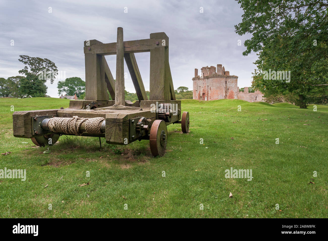 Caerlaverock castle with facsimile medieval catapult siege engine in the foreground Stock Photo