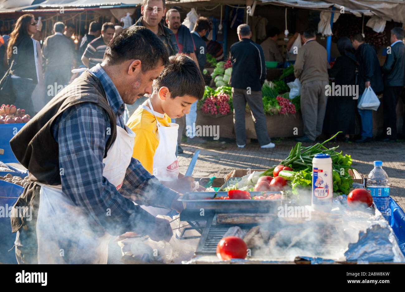 Turkish man and young boy cooking hot street food in market in Beyoğlu Istanbul Stock Photo