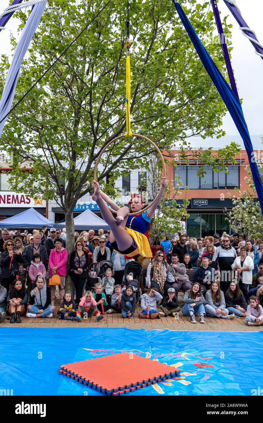 Melbourne, Australia - October 20, 2019: Aerial silks acrobat performing on the street in front of large crowd Stock Photo