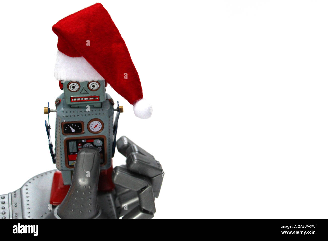 The robot holds a small retro robot in his hand. The robot has a Santa hat. Christmas and New Year celebration concept in the style of robots. White b Stock Photo