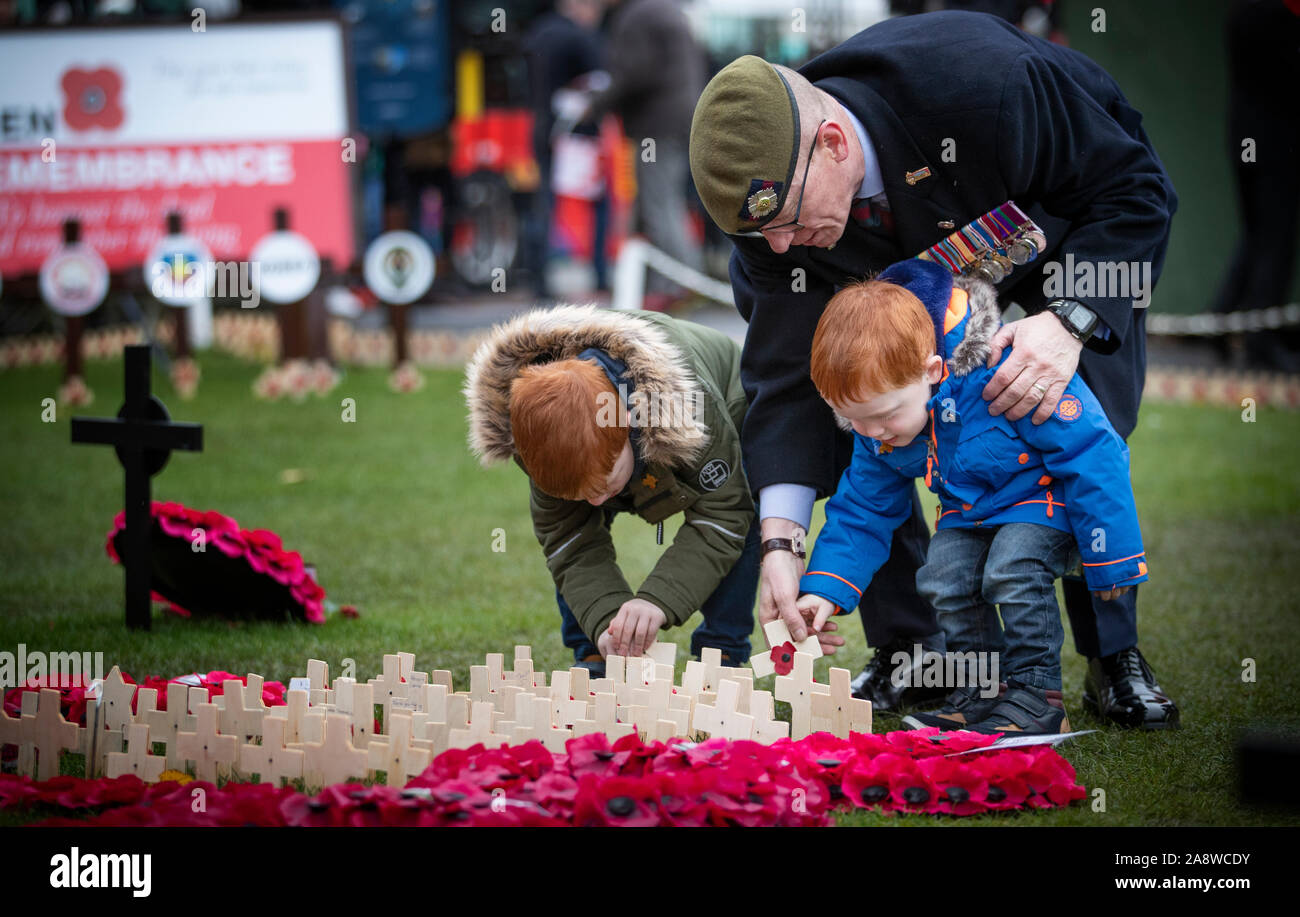 Former Scots Guard Brian Ward, from Cumbernauld, with his two sons Daniel, aged 2 (left) and Jack, aged 4 (centre), place crosses in the Edinburgh Garden of Remembrance to mark Armistice Day, the anniversary of the end of the First World War. Stock Photo
