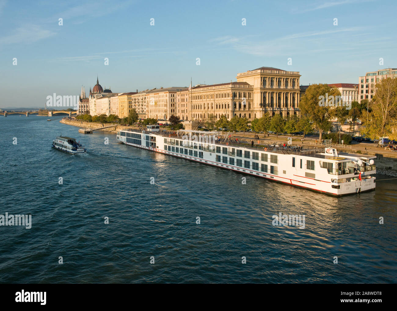 River Danube, Hungarian Academy of Sciences building and large river cruise boat. Pest, Budapest Stock Photo