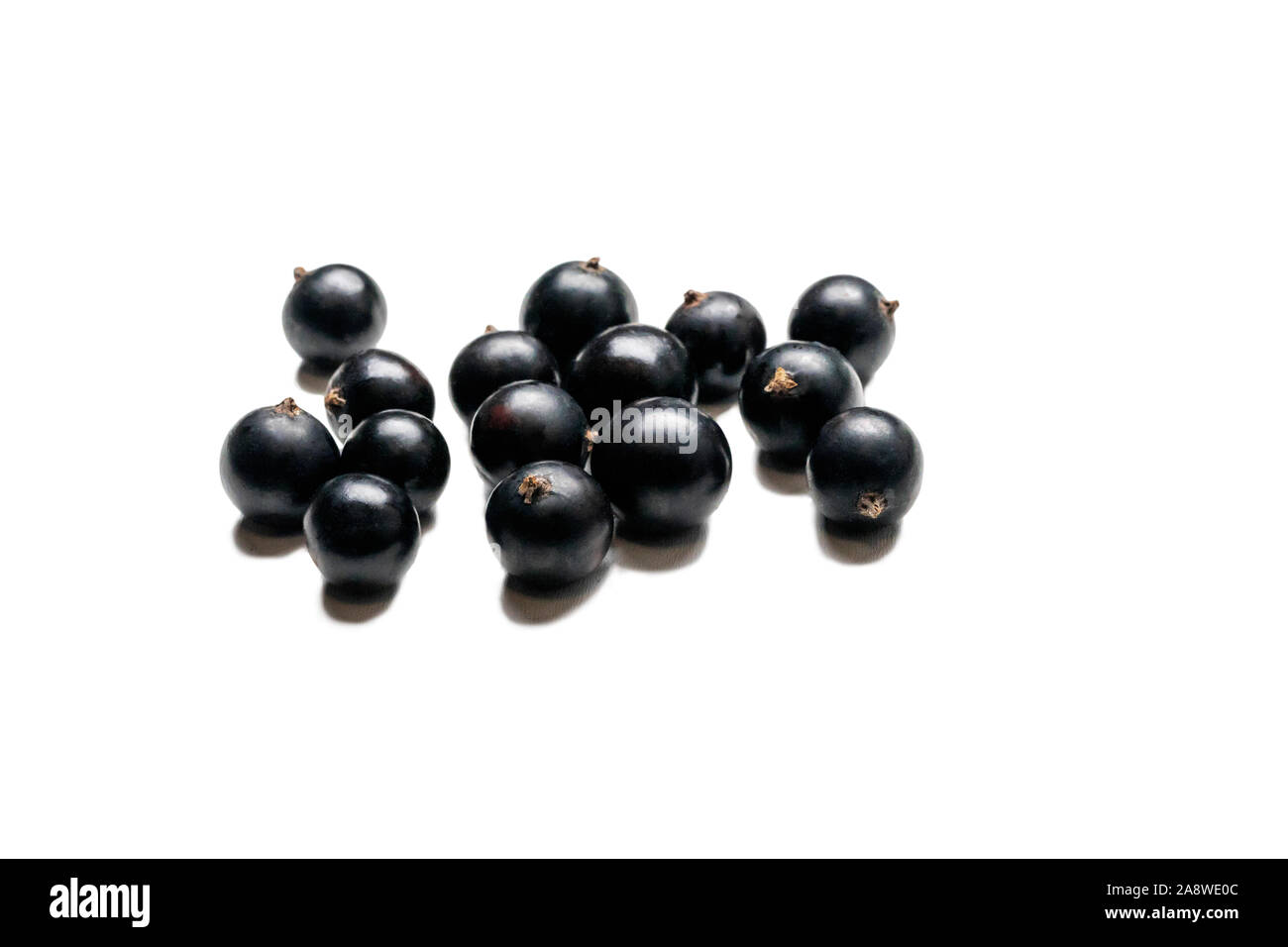 Blackcurrant isolated on a white background. Currant macro photo. Heap of black currant berry. Stock Photo