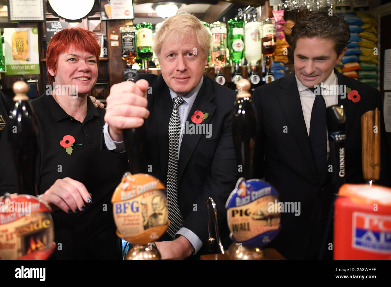 Prime Minister Boris Johnson, pulls a pint watched by Defence Minister Johnny Mercer (right) as he meets with military veterans at the Lych Gate Tavern in Wolverhampton. Stock Photo