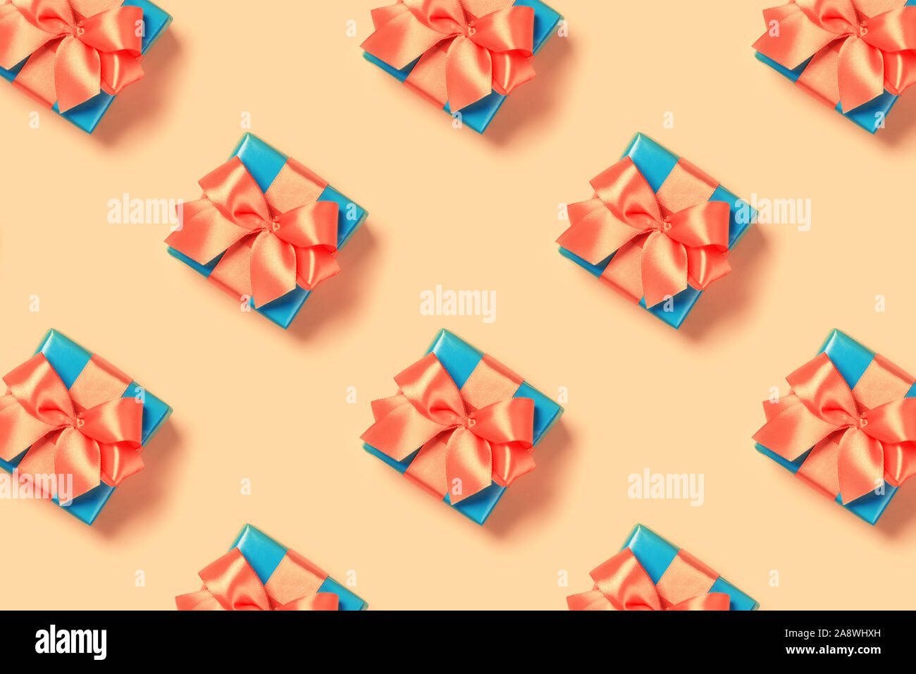 Pattern with stylish gift on a trendy coral background. Present for St. Valentine's day, engagements, Mother's Day, birthday, New Year, Christmas, holidays Stock Photo