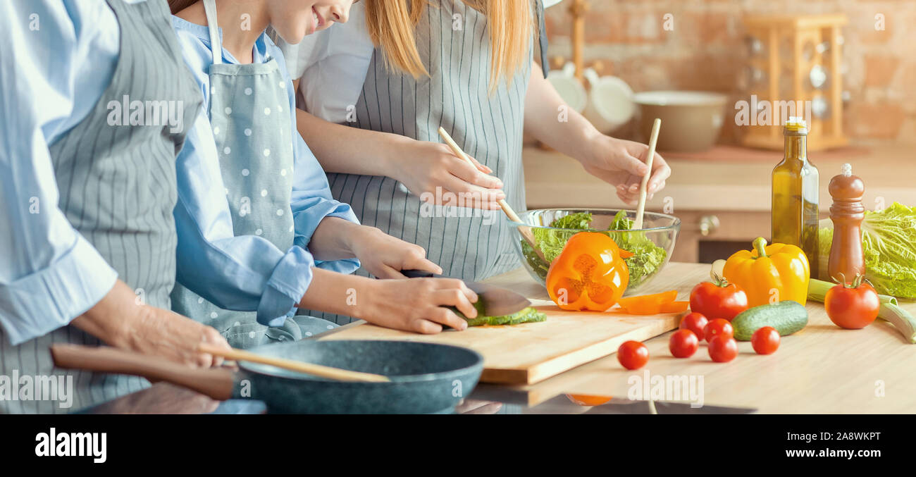 Cropped photo of three women cooking food together Stock Photo
