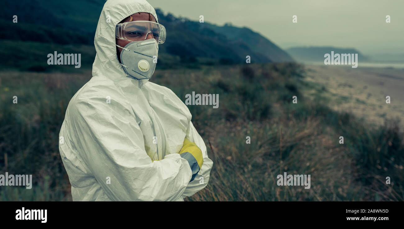 Man in bacteriological protective suit watching the sea Stock Photo