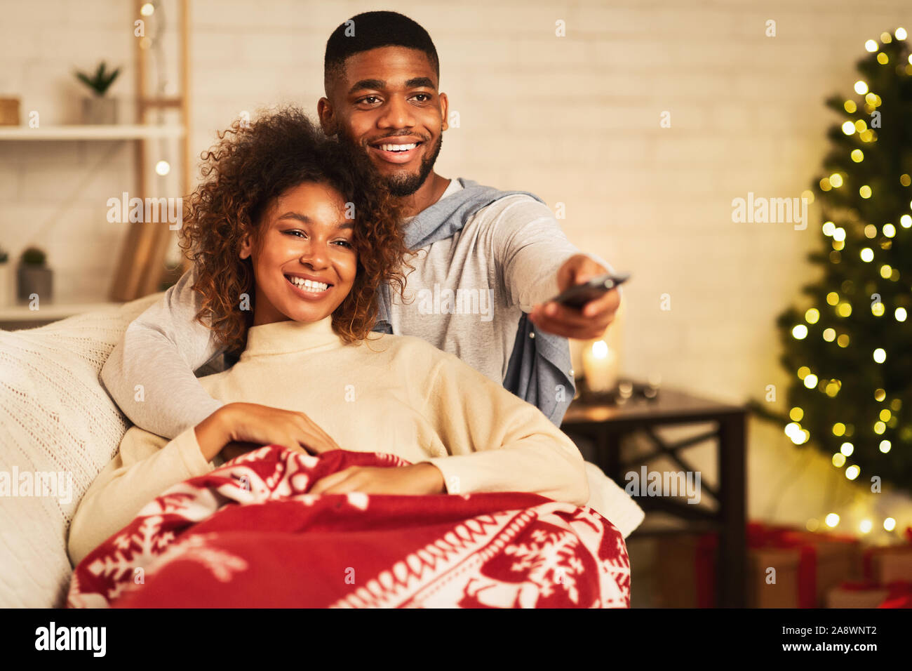 Afro couple in love at Christmas eve enjoy watching tv Stock Photo