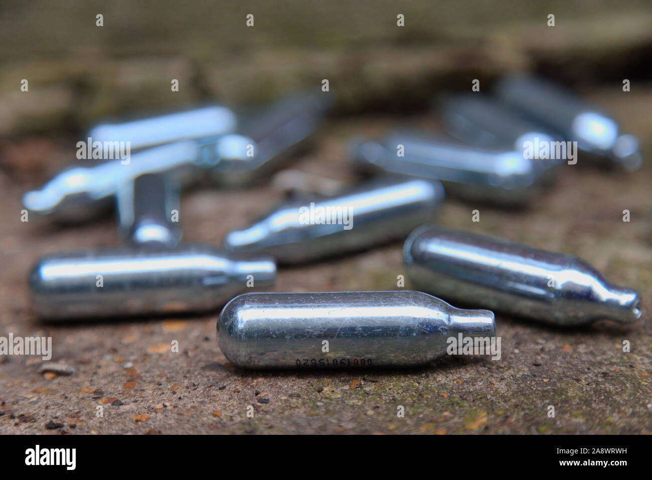 used Nitrous Oxide canisters on roadside in south London Stock Photo