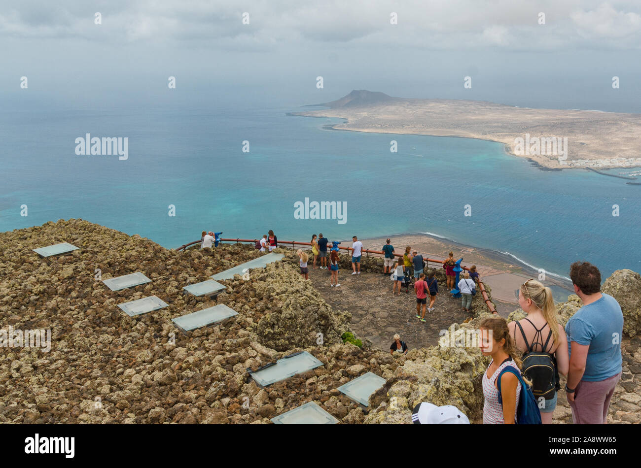 Lanzarote,Canary islands, Spain-August 31, 2018. Tourists enjoying the view to the Island of La Graciosa and the port of Caleta del Sebo from viewpoin Stock Photo