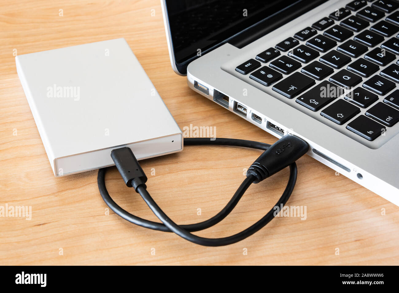 An external hard drive to connect to a laptop computer for data transfer or data backup. Stock Photo