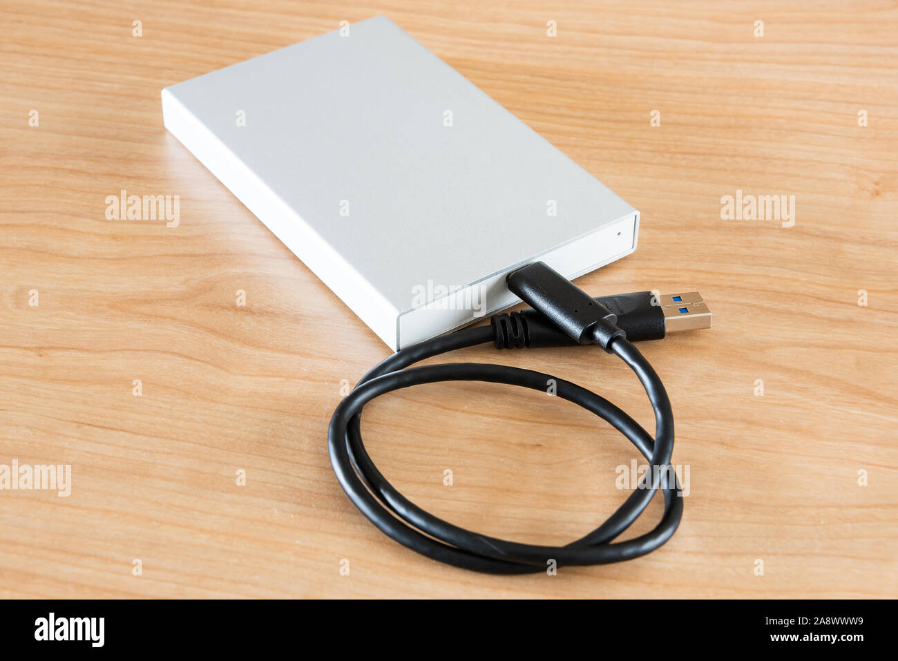 An external hard drive to connect to a laptop computer for data transfer or data backup. Stock Photo