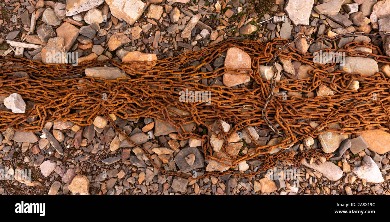 Old rusty chain on a rocky beach in Svalbard. Stock Photo