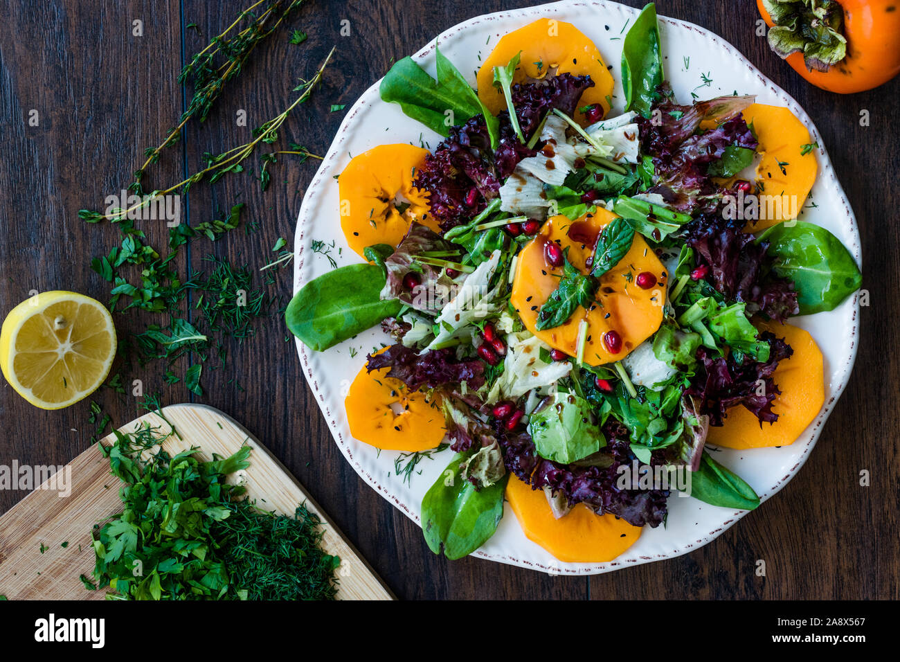 Persimmon Fruit Salad With Pomegranate Lollo Rosso Lettuce Rocket Arugula Or Rucola And Mint Leaves Organic Food Stock Photo Alamy