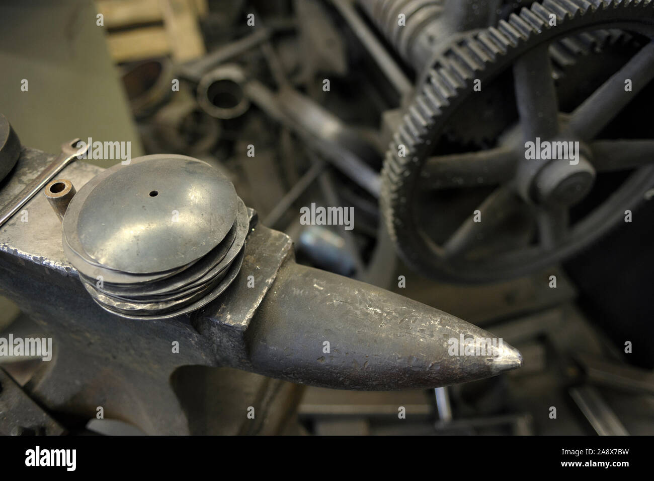 Anvil and machine cogwheels, detail of smithy Stock Photo