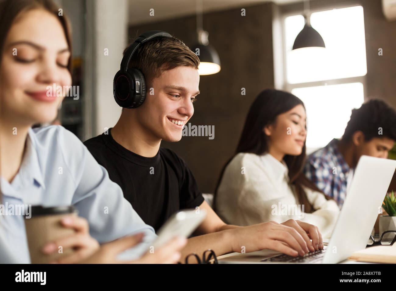 Smart smiling guy studying in school library Stock Photo