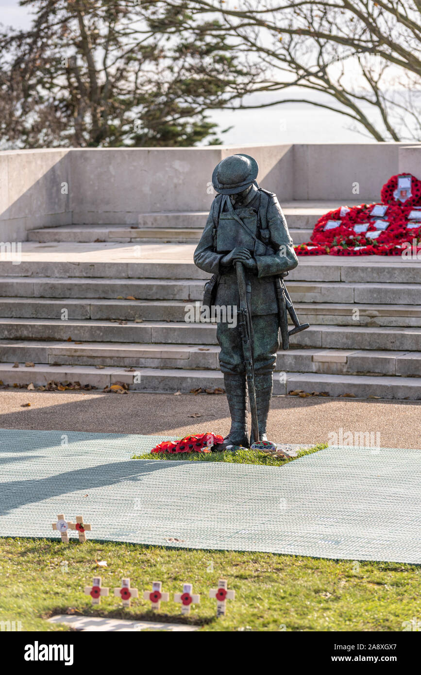 Bronze statue of a British ‘Tommy’ soldier in front of the Lutyens designed war memorial in preparation for Remembrance Sunday. Wreaths Stock Photo