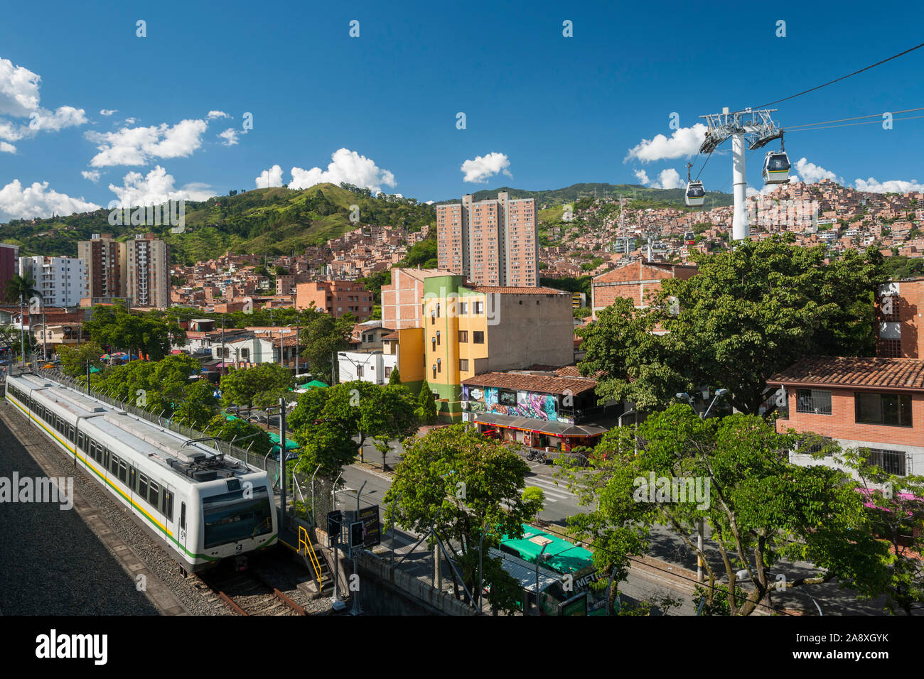 San Javier metro station showing a train and the metrocable leading to comuna 7 in Medellin, Colombia. Stock Photo