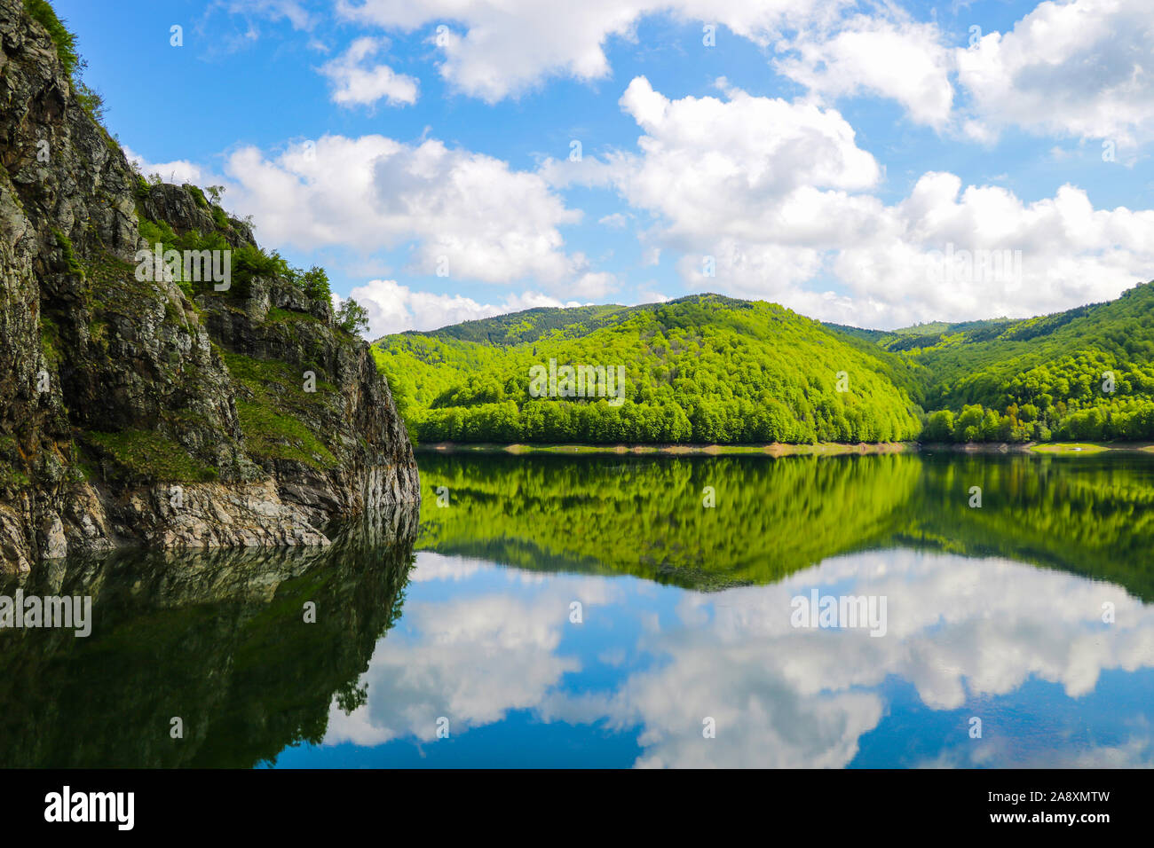 Nice view of the mountains and green hills. Reflection of hills in a lake Stock Photo