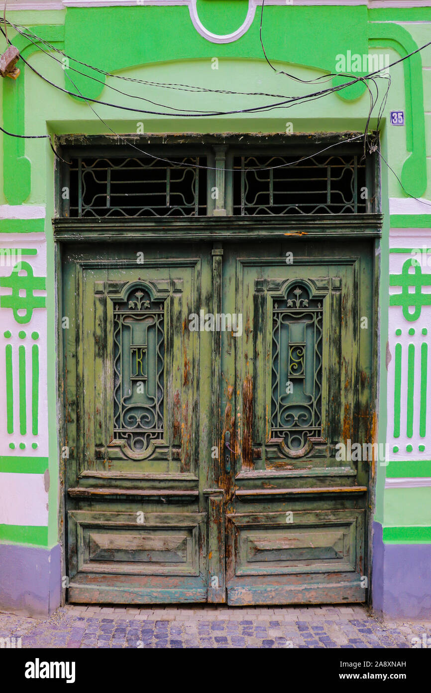 Sibiu, Romania, May 15, 2019: Traditional, colorful, decaying wooden courtyard doors of old townhouses in the center Stock Photo