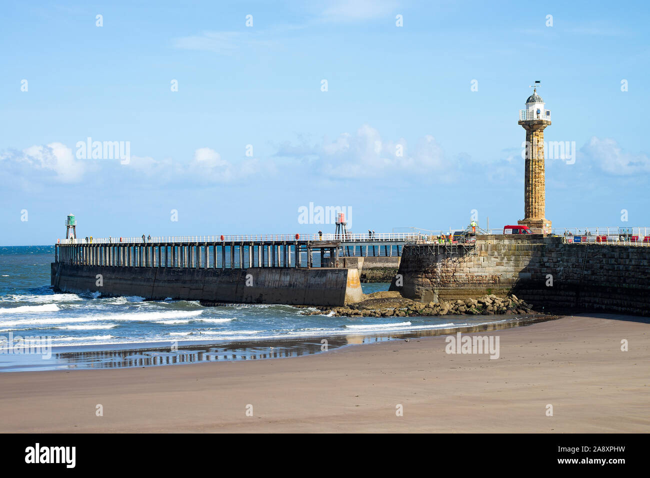 The Beautiful Sandy Beach at Whitby Together With Sea Wall and Entrance to the River Esk Estuary and Lighthouse North Yorkshire England UK Stock Photo