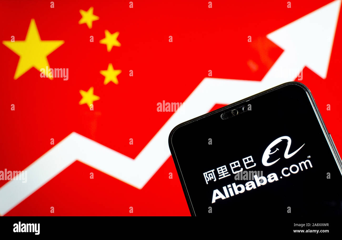 Alibaba logo on the smartphone and a blurred background with China flag and an arrow showing the growth. Conceptual photo. Stock Photo