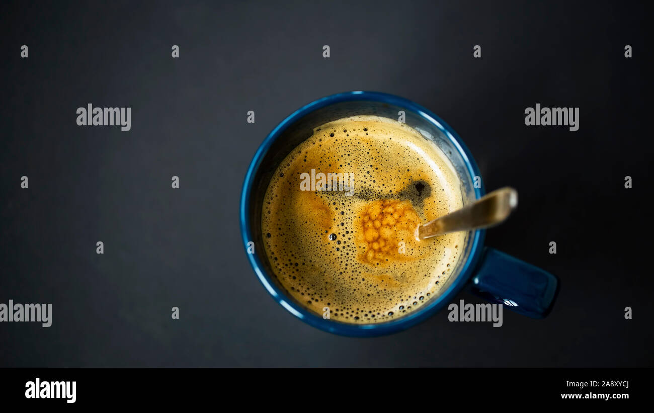 Espresso coffee cup top view with spoon on dark background Stock Photo