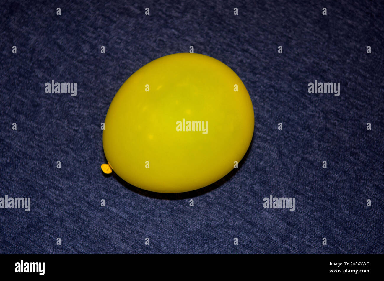 A Close Up Of An Inflated Yellow Party Balloon On A Carpeted Office ...