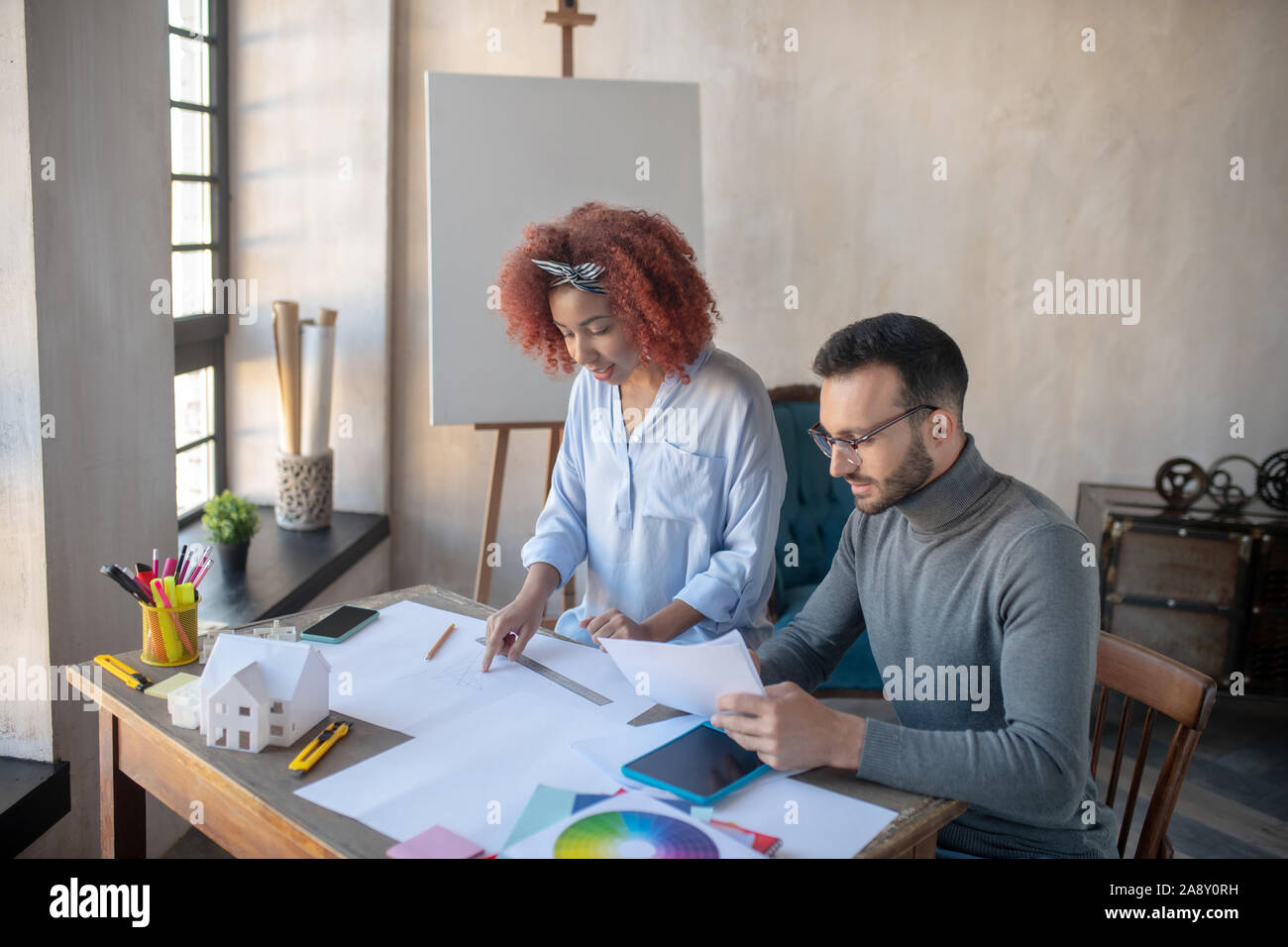 Two interior designers sitting at the table and working Stock Photo