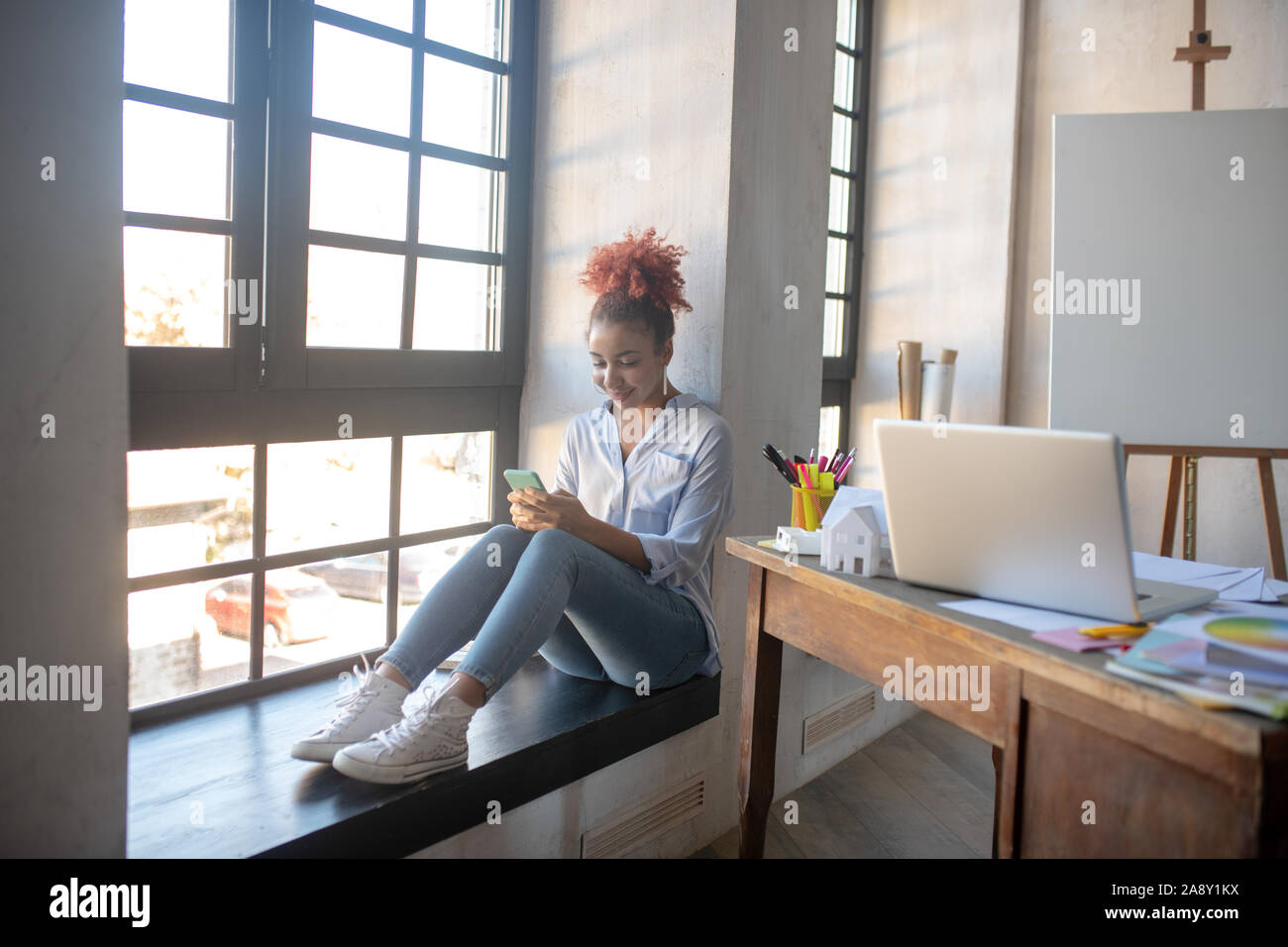 Designer enjoying break while using smartphone Stock Photo