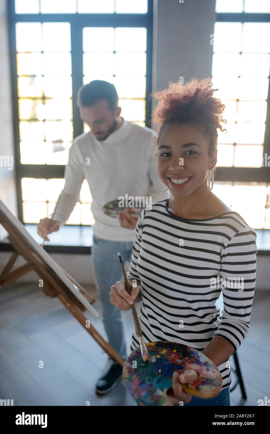 Cheerful young woman feeling inspired before painting Stock Photo