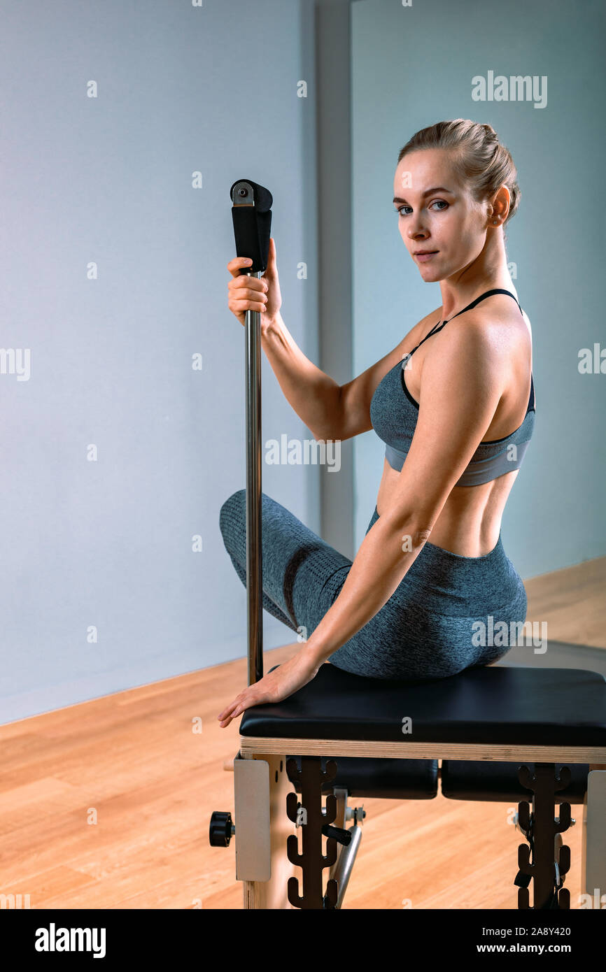 Pilates woman in a Cadillac reformer doing stretching exercises in the