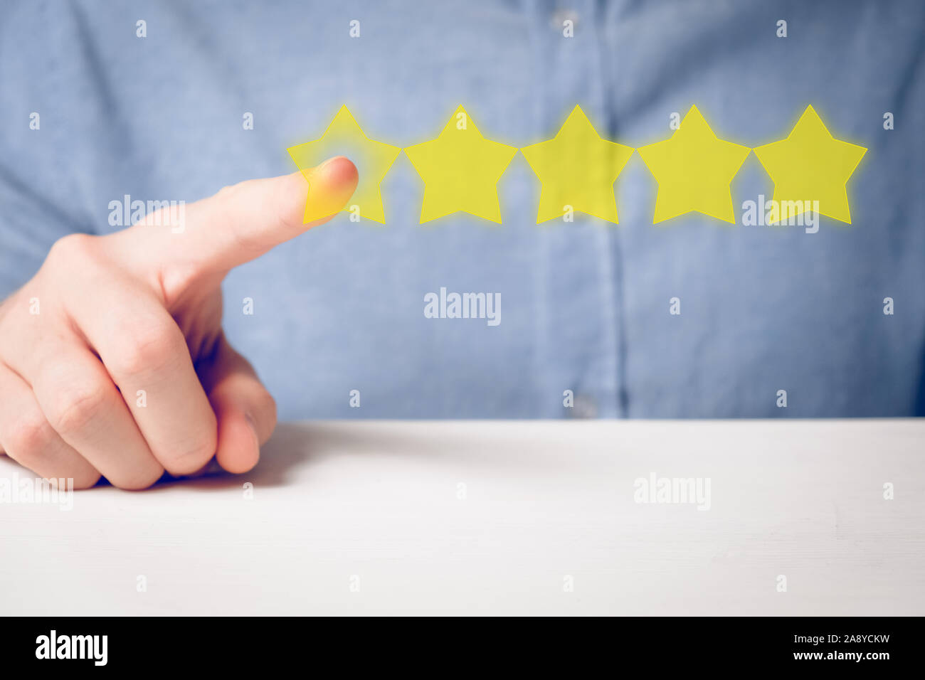 A man in a shirt abstractly ratings five stars with his finger. best score. Close up. Stock Photo