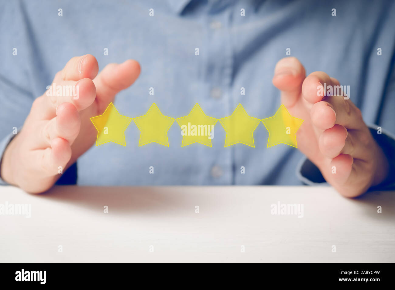 A man in a shirt abstractly shows the rating with his hands five stars. Best score. Close up. Stock Photo