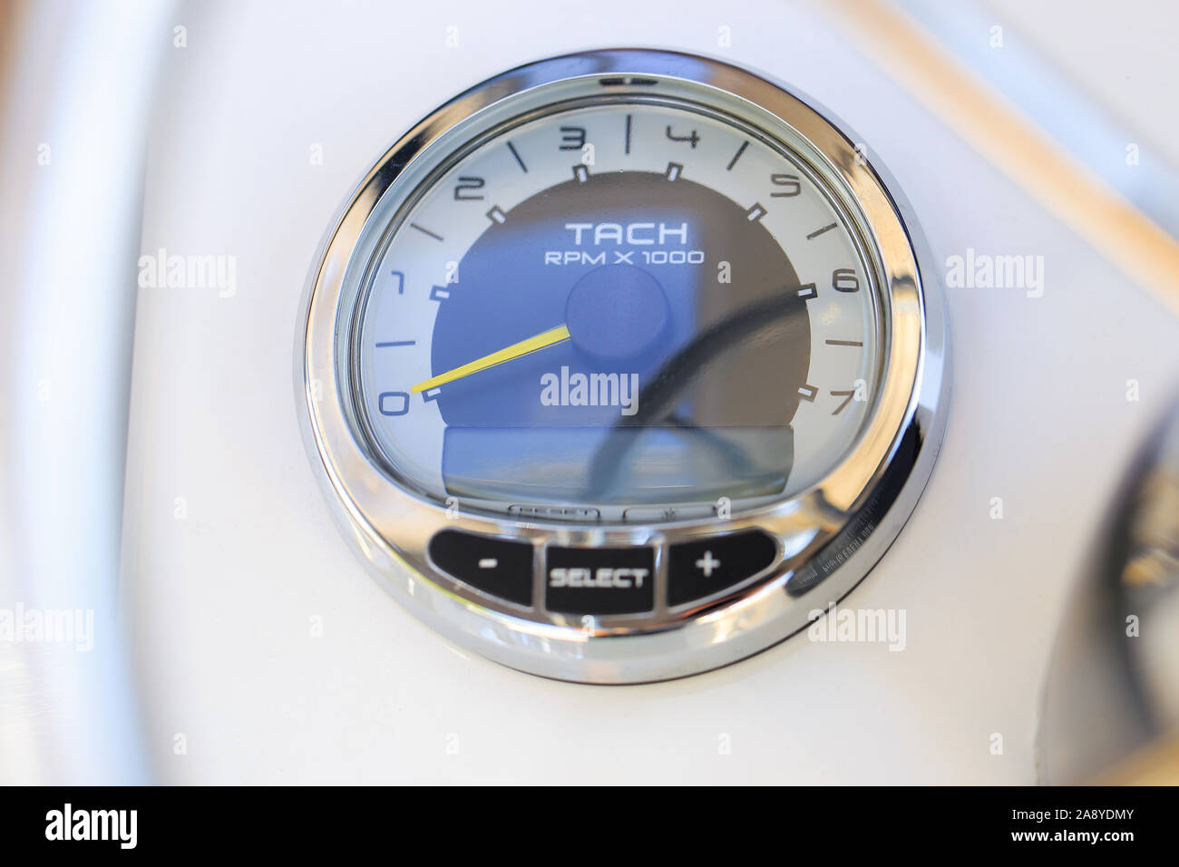 Analog tachometer on the white dashboard control panel of the motor