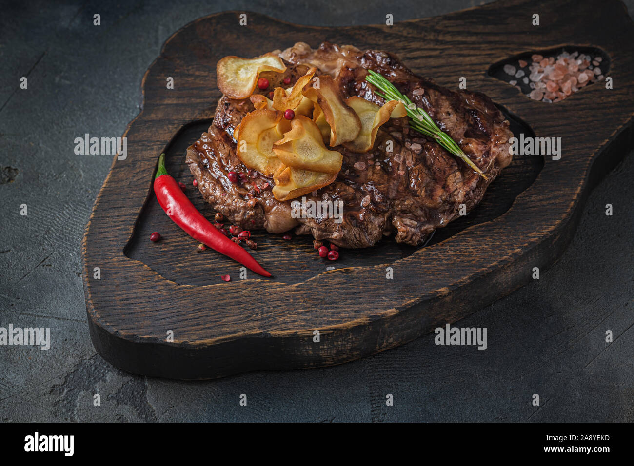 Beef chuck roll steak on wooden board, close view Stock