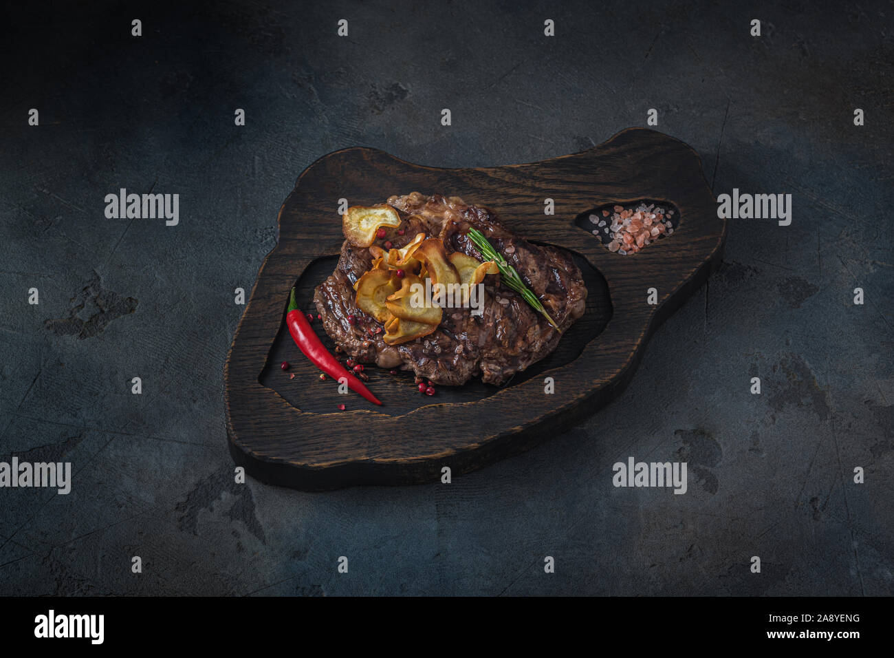 Roasted beef chuck roll steak with chilli pepper, copy space Stock