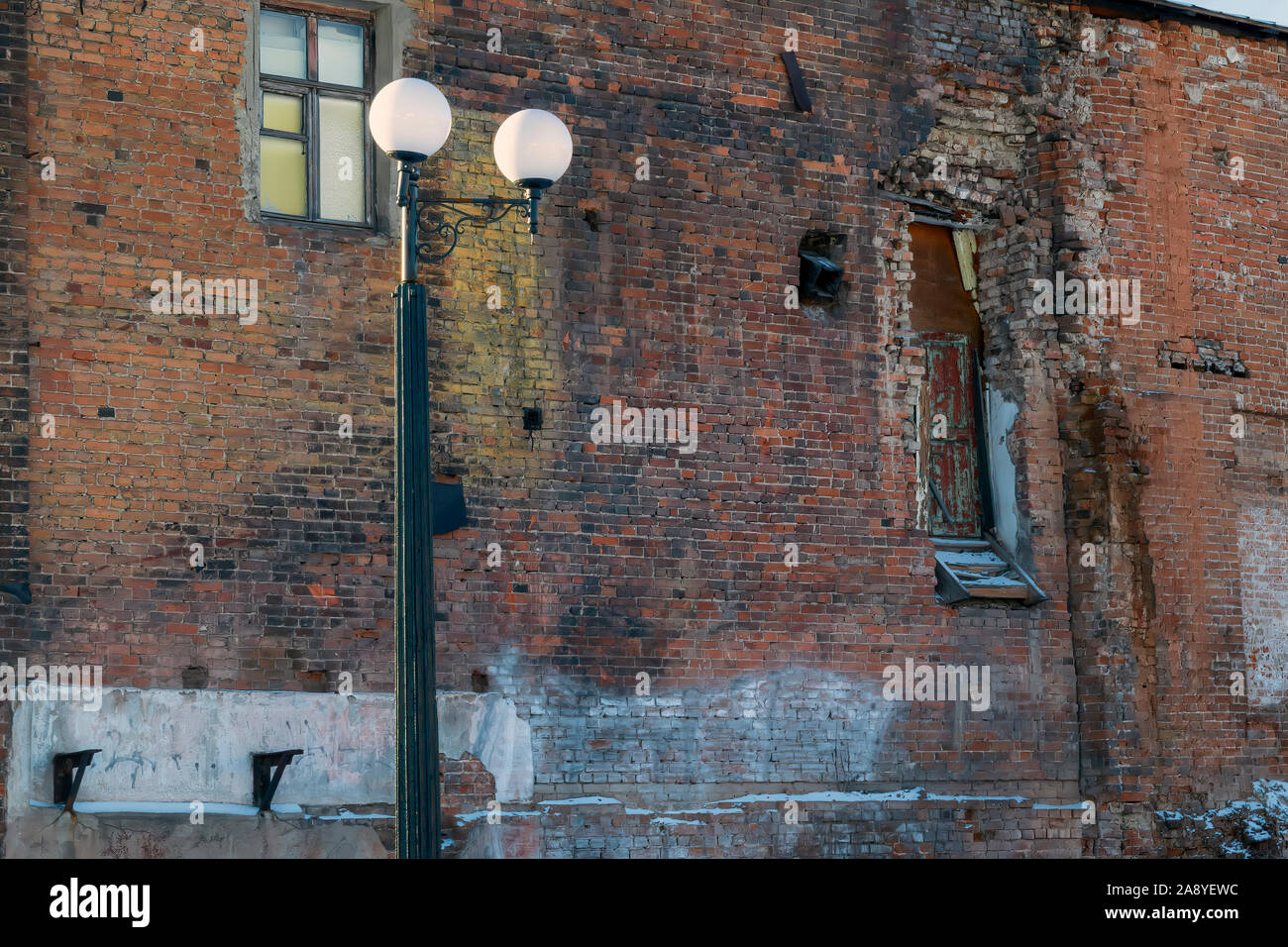 Detail of an old crumbling red brick building close-up. Old broken wall with bricks texture. Stock Photo