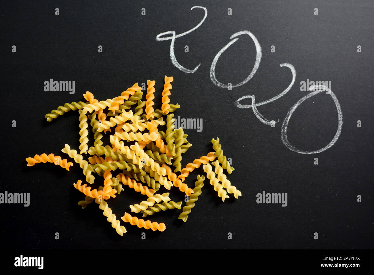 Uncooked fusilli over black background with number 2020 from above Stock Photo