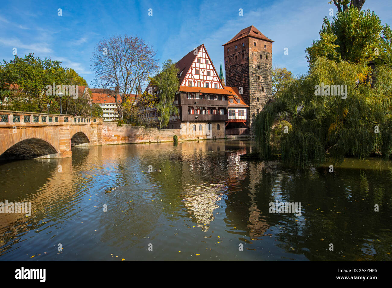 The beautiful view over the Pegnitz river towards Weinstadel House, Hangmans Tower and the Maxbrucke stone bridge, in the city of Nuremberg, Germany. Stock Photo