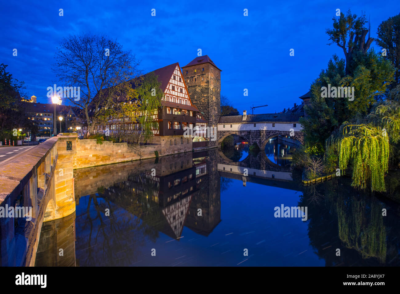 The beautiful evening view from the Max Brucke bridge over the Pegnitz river towards Weinstadel House, Hangmans Tower and the Henkersteg, in Nuremberg Stock Photo