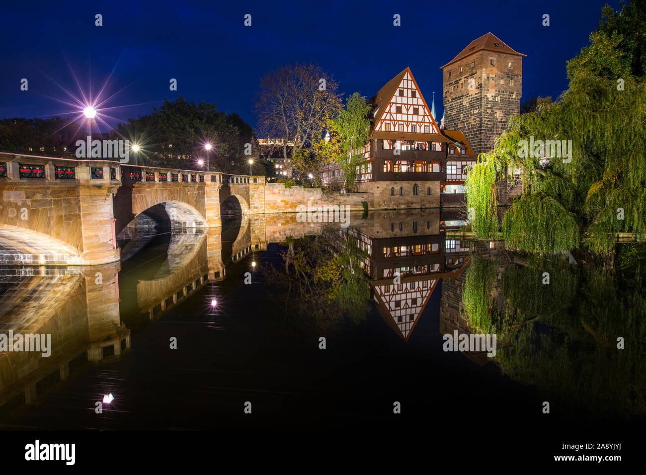 The beautiful evening view over the Pegnitz river towards Weinstadel House, Hangmans Tower and the Max Brucke bridge, in Nuremberg, Germany. Stock Photo