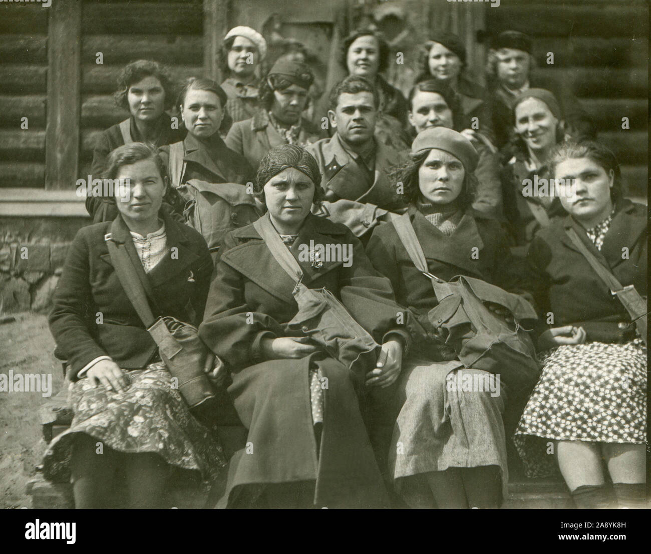 1937 year. Military garrison. The officer of the Red Army, along with the wives of the command staff, was photographed after the civil defense exercises. Women have bags with gas masks on their shoulders. THE USSR. Stock Photo