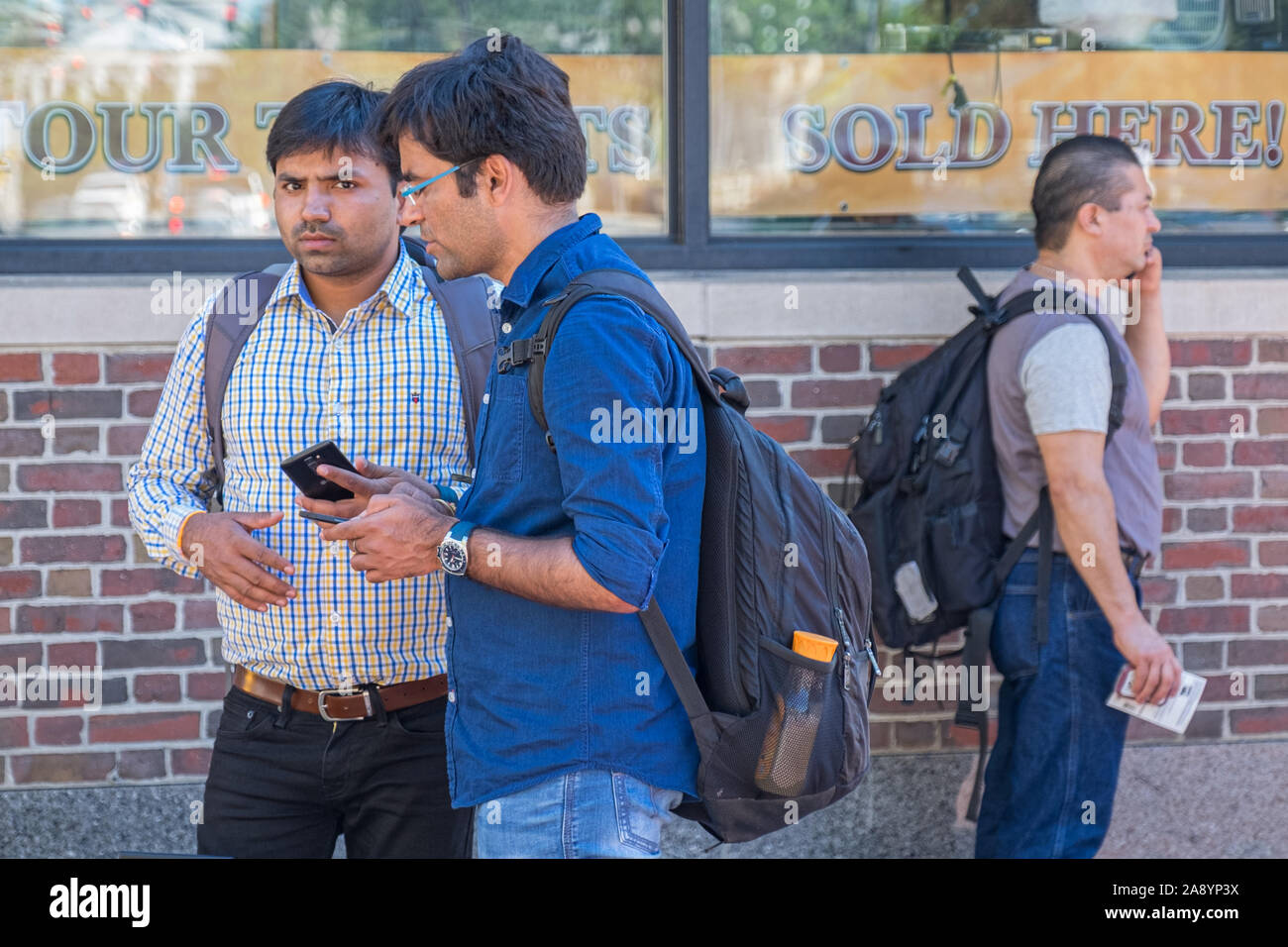 Three students in Harvard Square using a mobile phone Stock Photo Alamy