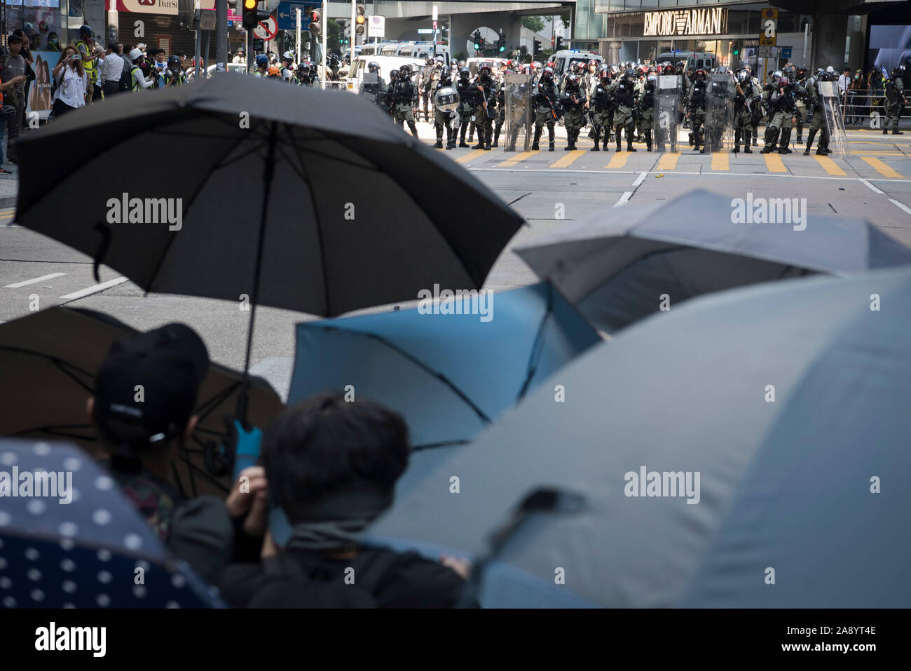 Protesters stand off with police using umbrellas during the demonstrations.Thousands of office workers and masked protesters clash with police in one of the most violent days for the financial hub since the protests began five months ago, a police officer shot a masked protester and another man was doused in fuel and set on fire. Despite the controversial extradition bill which originally sparked the protests being formally withdrawn, protesters continue to call on Chief Executive Carrie Lam to meet their remaining demands which includes complete universal suffrage, an independent investigatio Stock Photo